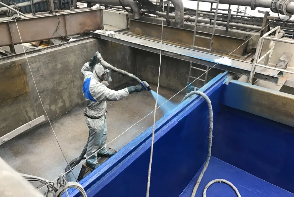 Spray application of a protective coating inside an industrial area